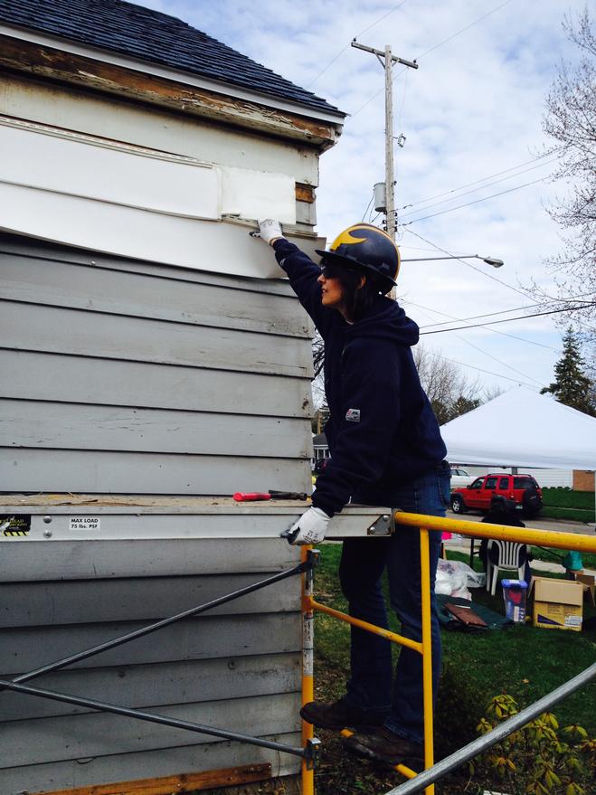 Dawn Boucher tearing down siding for Habitat for Humanity 